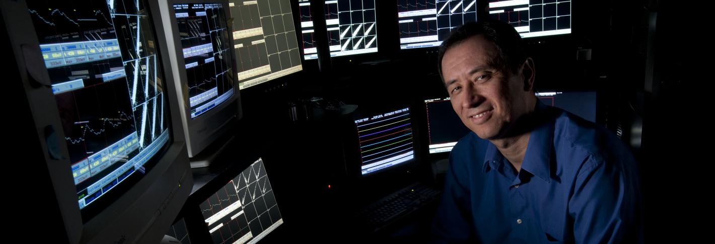 Matt Wilson sits before a bank of monitors showing readouts of neural data