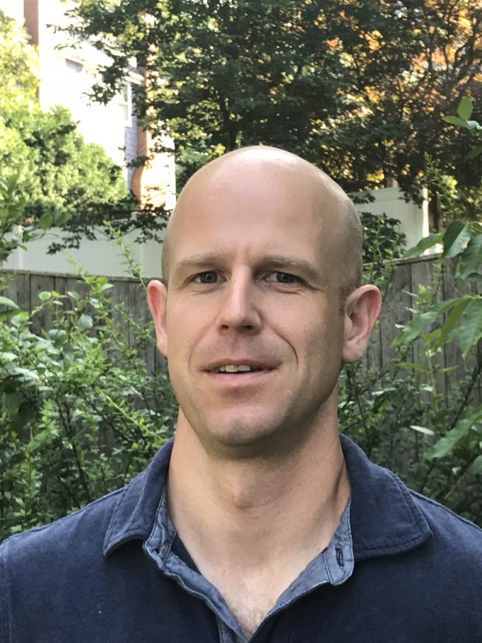 A portrait of Joel Blanchard standing in a garden